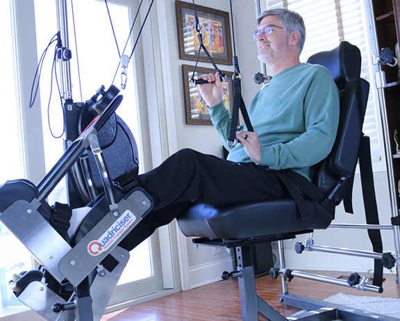 man on the quadriciser in his livingroom